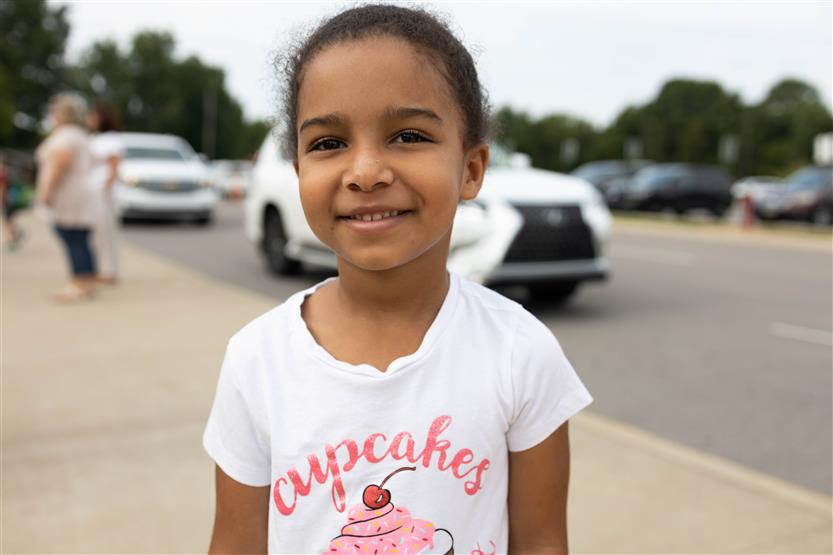 A girl wearing a white shirt smiles